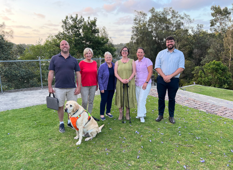 Members of Council's Access and Inclusion Committee posing for a photo with a guide dog.