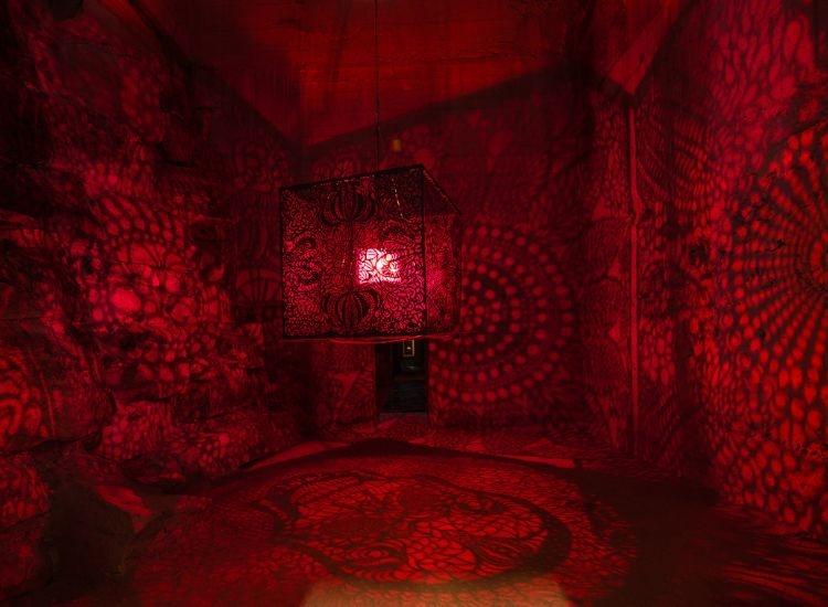 sculpture in centre of dark room with red light