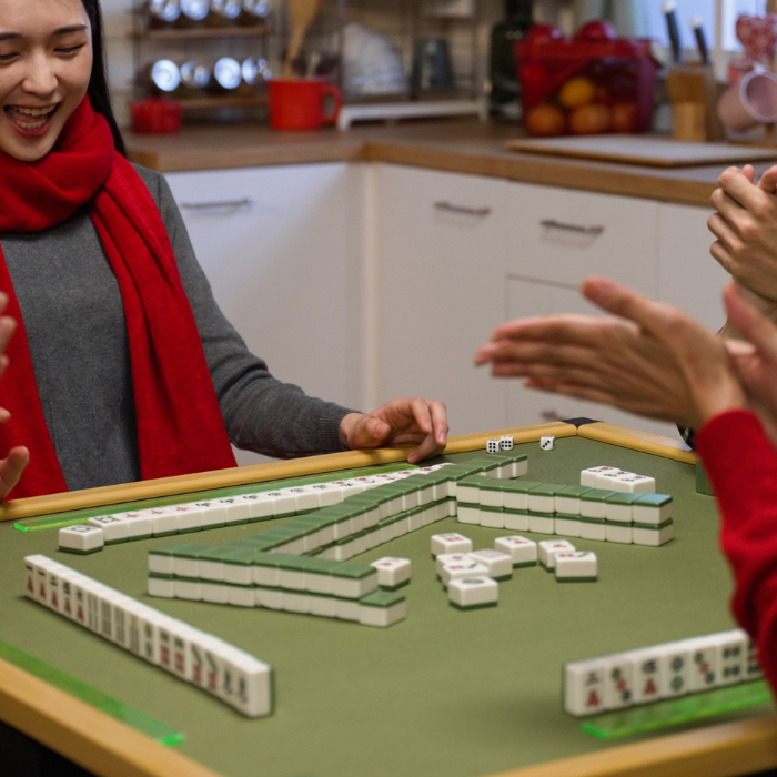 A table of mahjong tiles being played by a Chinese family