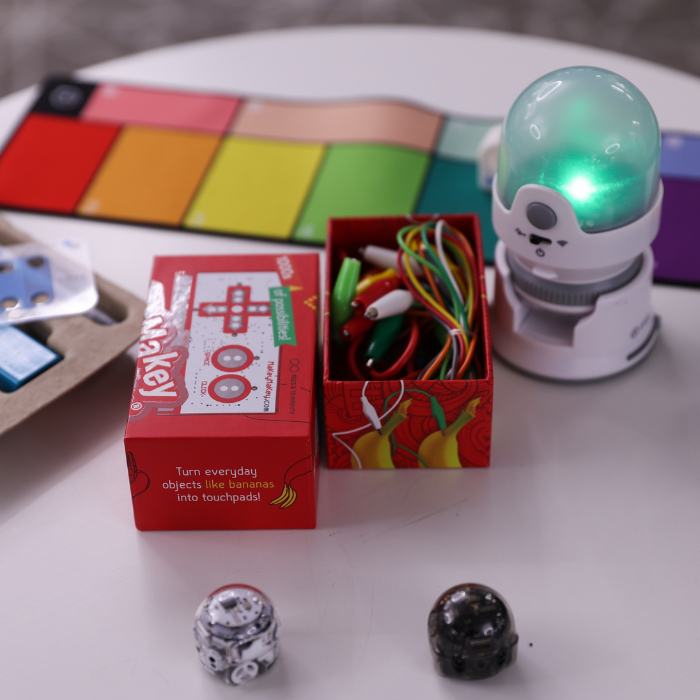 Image of a few maker kits spread across the table, including Makey Makey and digital microscope.