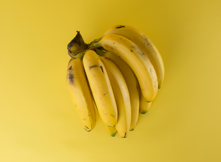 Ripe bananas on a yellow background