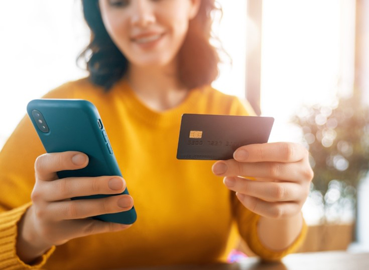 woman holding smartphone and credit card