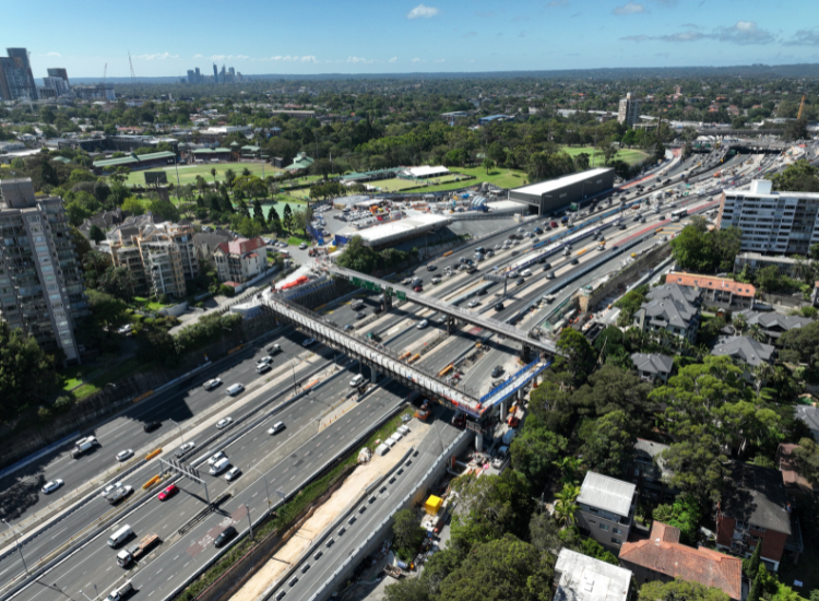 An aerial view showing two pedestrian bridges over a busy freeway