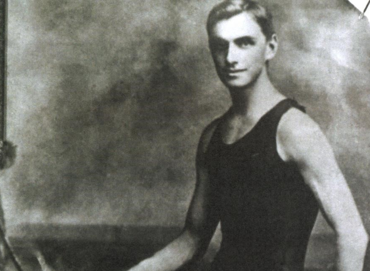 black and white image of young man with light hair in a full piece swimming costume