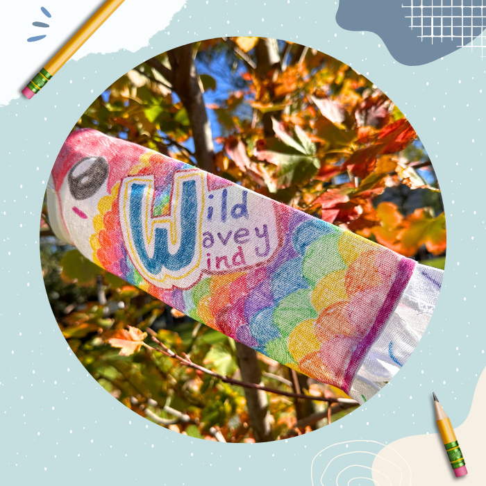 Photo of a decorated windsock in the style of a rainbow Japanese koi fish with stylised words 'Wild Wavey Wind'