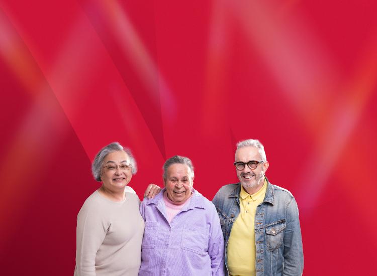 Two women and a man with linked arms, smiling on a red background